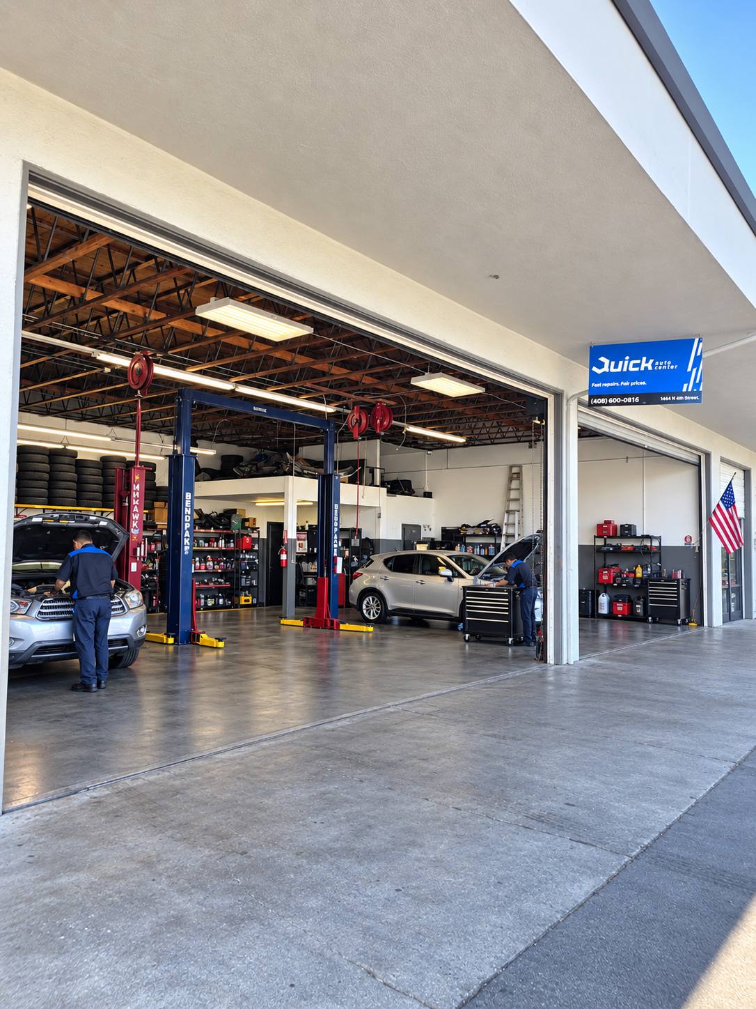 Inside the service bays at Quick Auto Center in San Jose, with technicians working on cars on the lifts